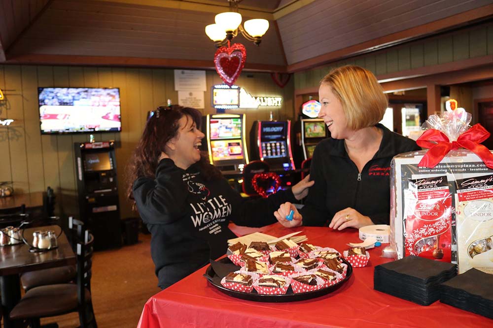two women laughing inside sammy's pizza during chocolate tour