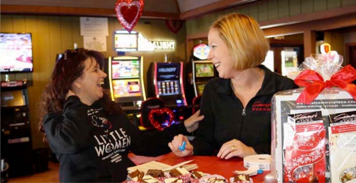 two women laughing inside sammy's pizza during chocolate tour