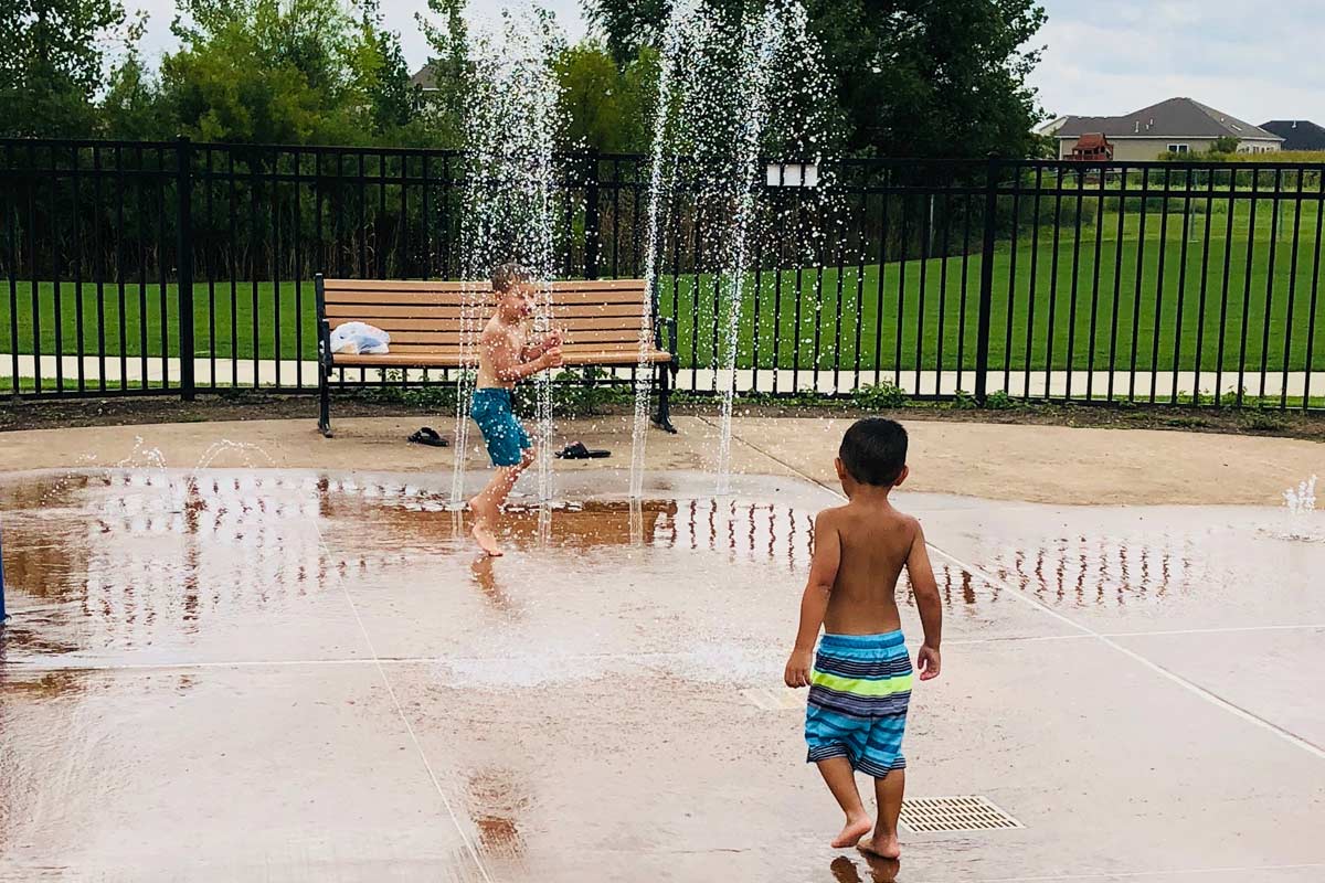 two kids playing at diamond point park splash pad